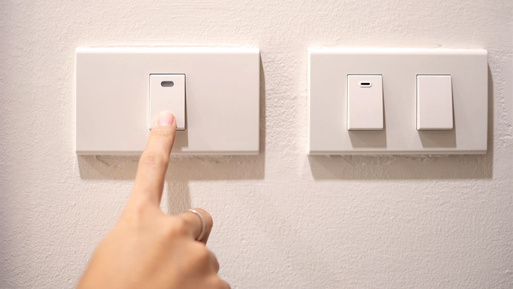 Mulher desligando interruptor de luz